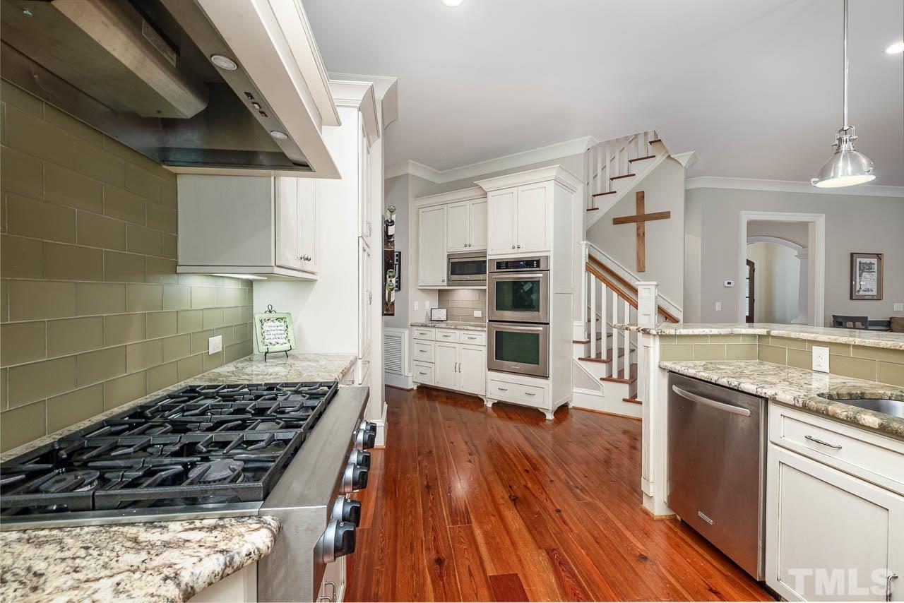 2129 Buckingham Road Raleigh, NC 27607 - Photo 23 of 52 a kitchen with granite countertop a stove and a wooden floors