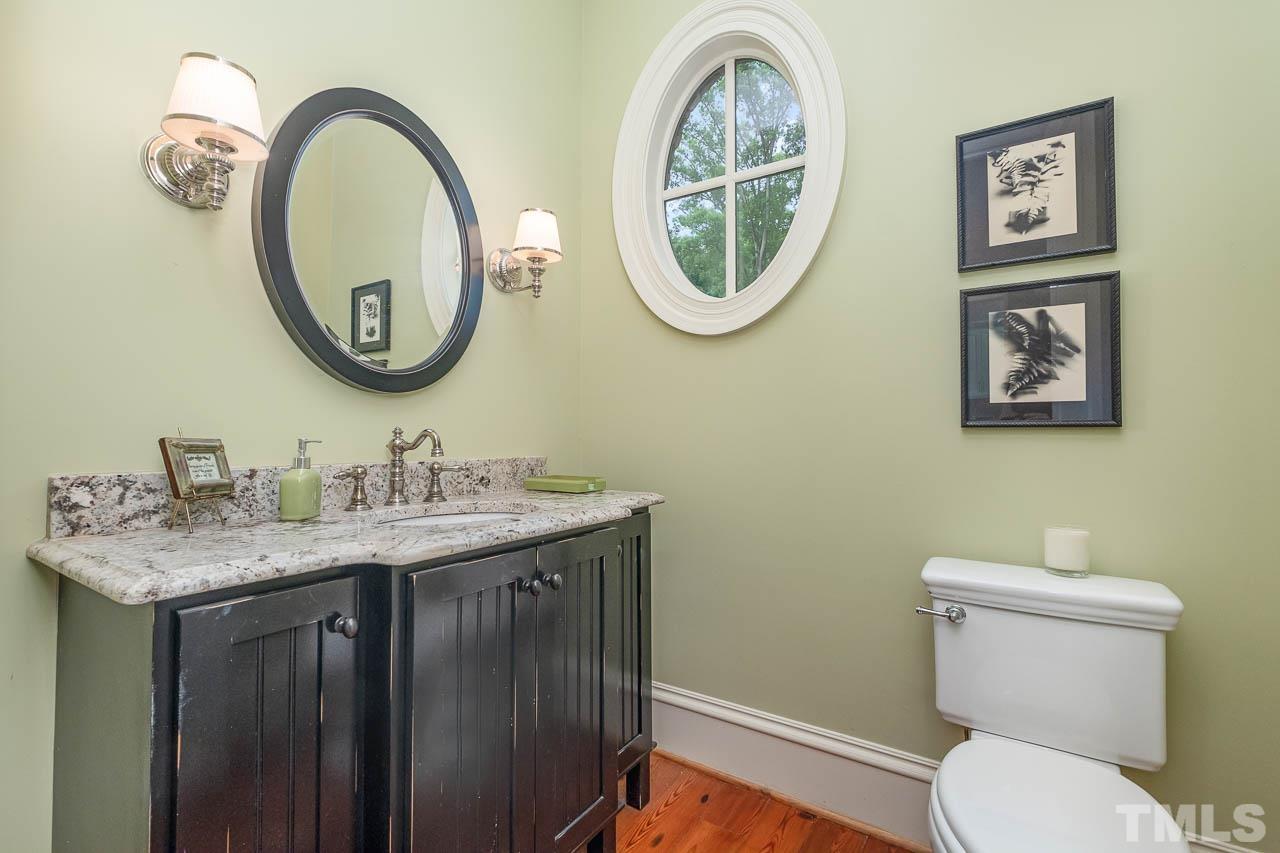 2129 Buckingham Road Raleigh, NC 27607 - Photo 27 of 52 a bathroom with a toilet a sink and a mirror