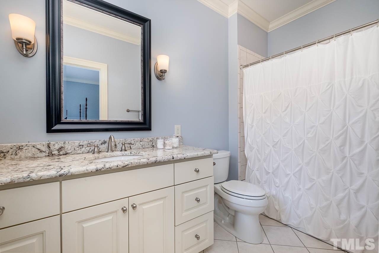 2129 Buckingham Road Raleigh, NC 27607 - Photo 40 of 52 a bathroom with a granite countertop sink a toilet and a mirror