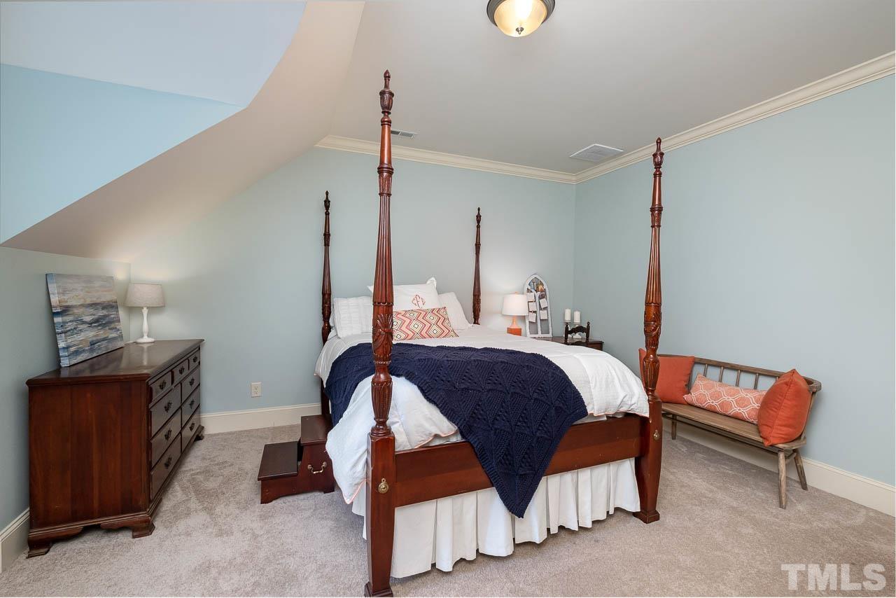 2129 Buckingham Road Raleigh, NC 27607 - Photo 42 of 52 a bedroom with a bed a lamp and a closet
