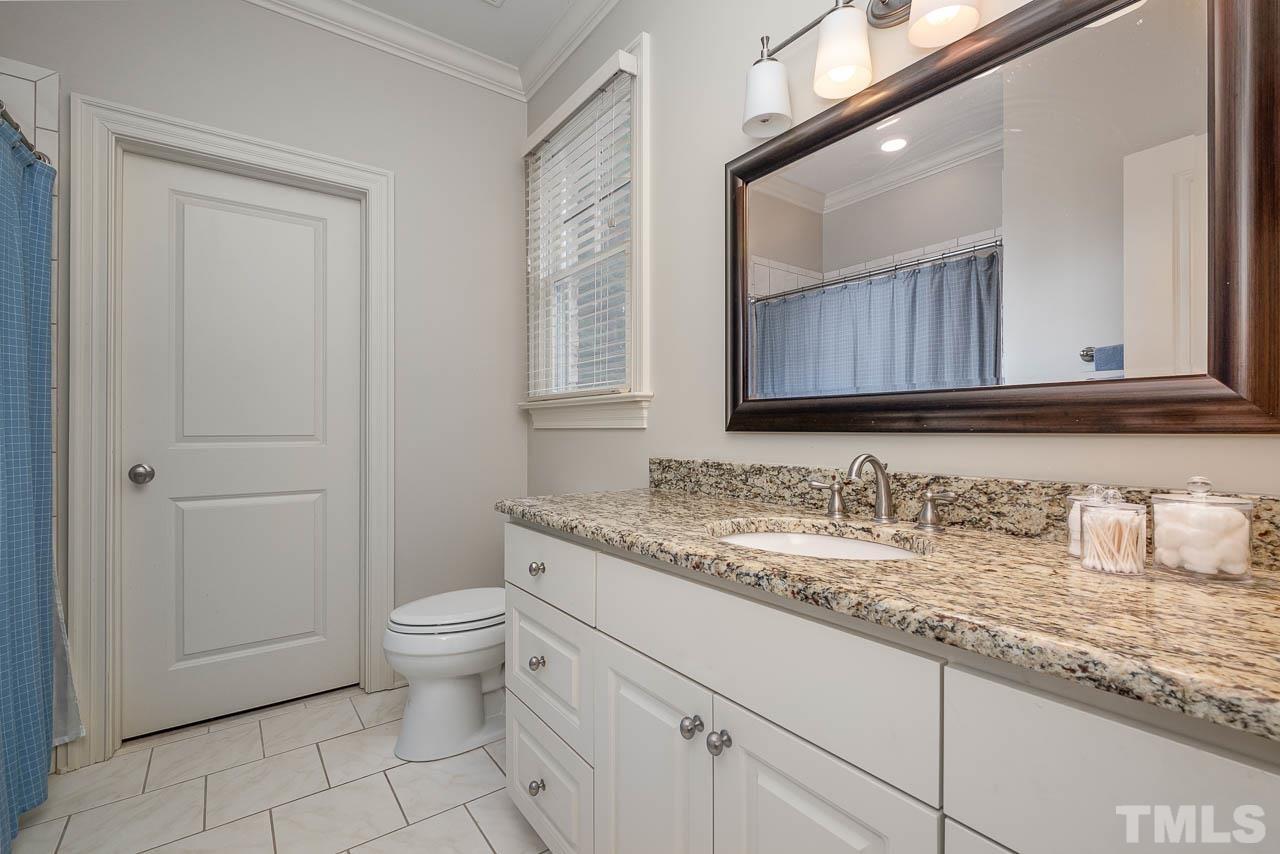 2129 Buckingham Road Raleigh, NC 27607 - Photo 46 of 52 a bathroom with a granite countertop toilet sink and mirror