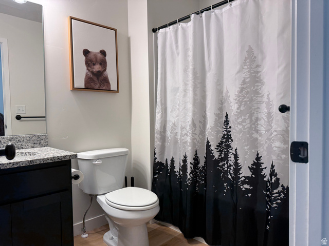 774 West 480 South American Fork, UT 84003 - Photo 63 of 76 Bathroom featuring a dark wood-finish vanity with a light speckled countertop, a toilet, and light wood-finish flooring