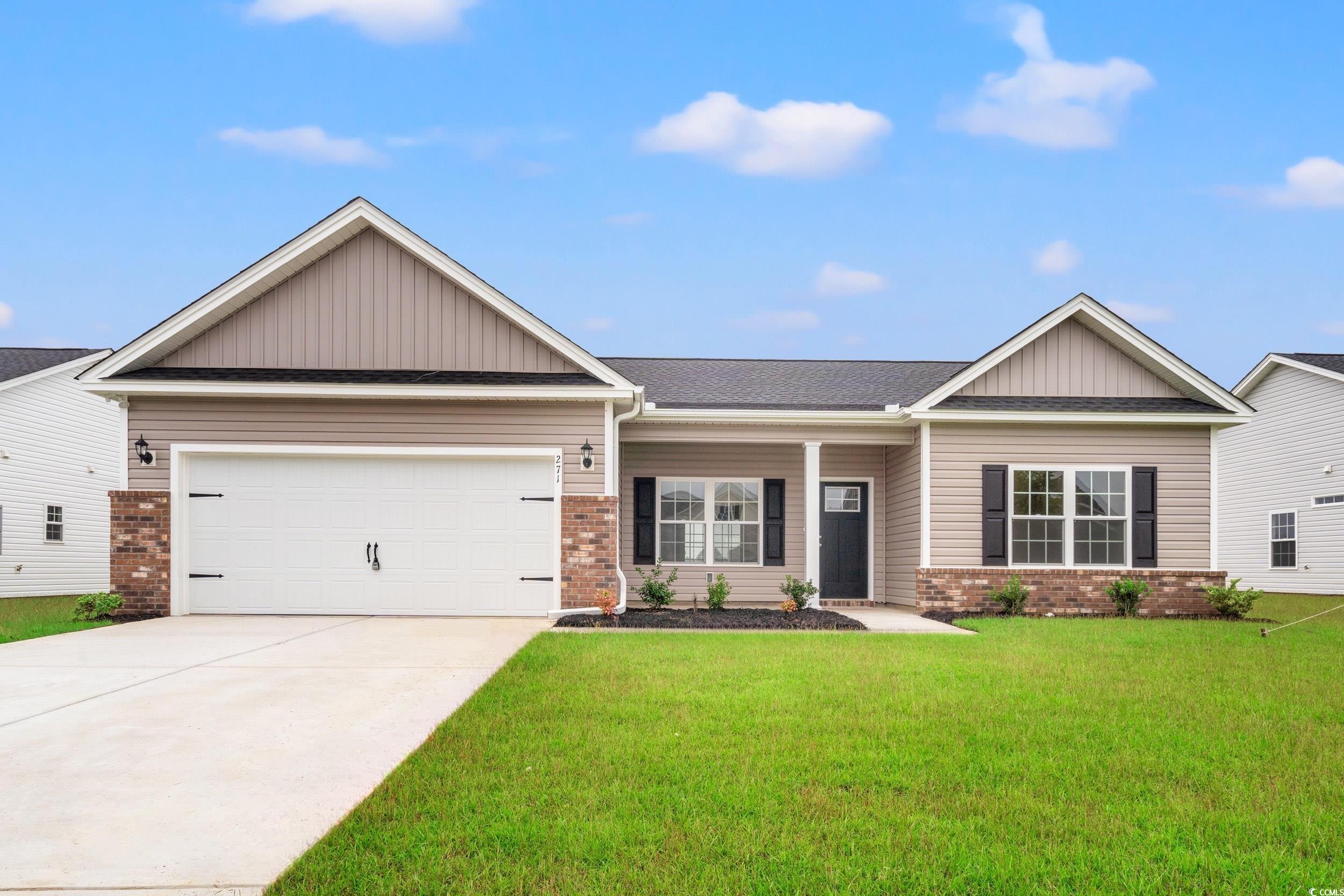 View of front of property with brick siding, board and batten siding, covered porch, and concrete driveway