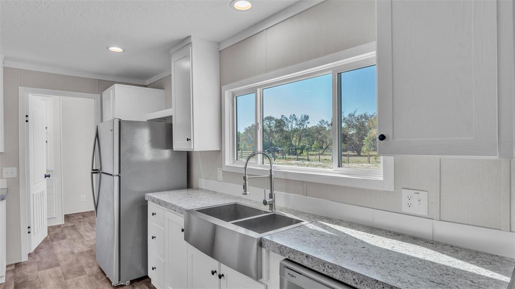 5535 Lake Buffum Road Lake Wales, FL 33859 - Photo 11 of 48 a kitchen with granite countertop a sink and a refrigerator