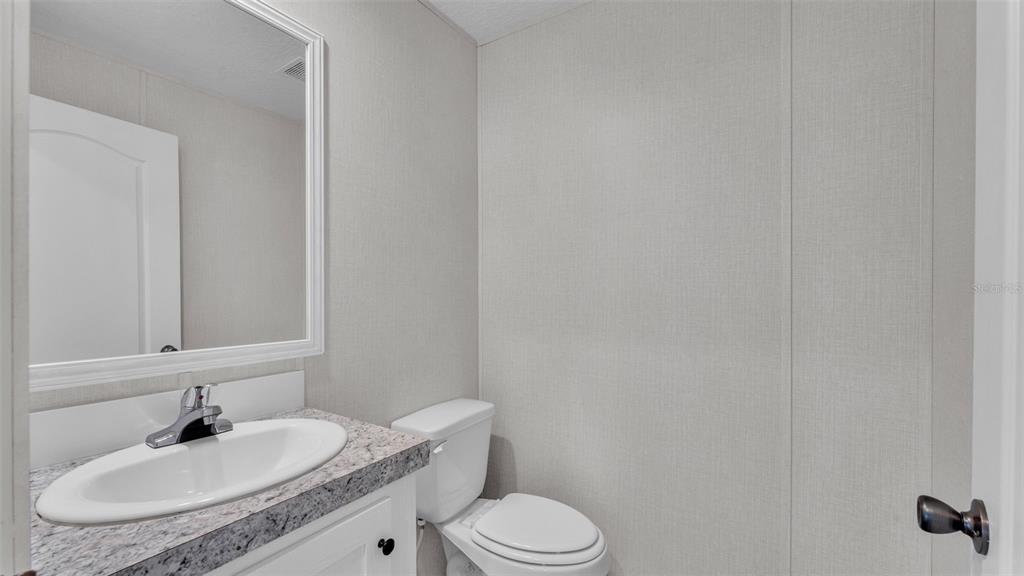 5535 Lake Buffum Road Lake Wales, FL 33859 - Photo 27 of 48 a bathroom with a granite countertop sink toilet and a mirror