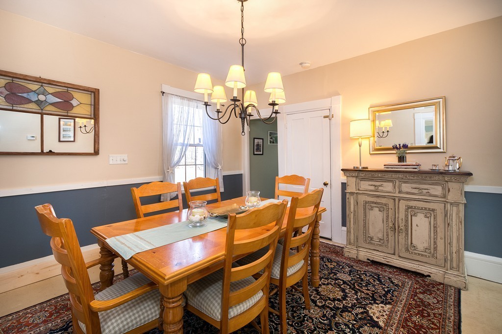 259 First Parish Road Scituate, MA 02066 - Photo 17 of 29 a dining room with wooden floor a chandelier a wooden table and chairs