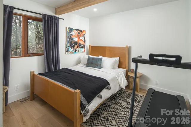 a bedroom with a bed and wooden floor