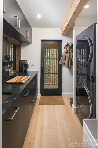 a kitchen with stainless steel appliances granite countertop a sink a stove and a wooden floors