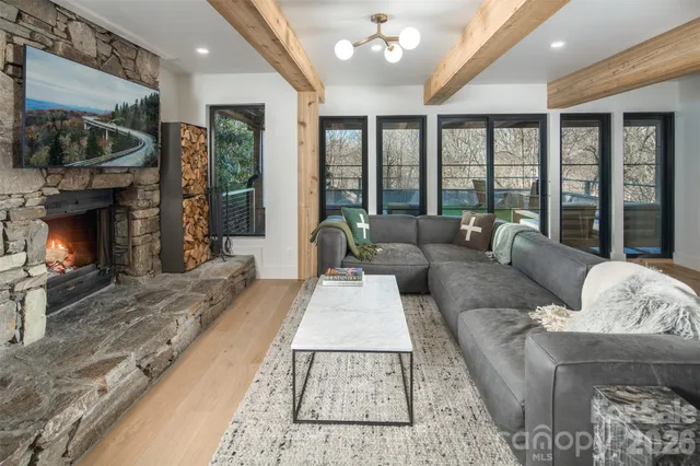 a living room with furniture a large window and a fireplace