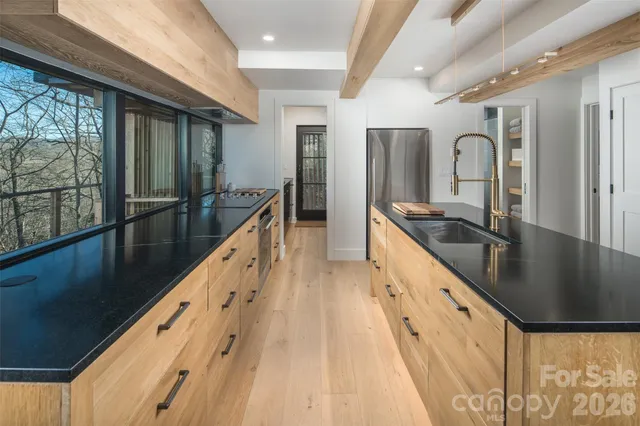a kitchen with granite countertop a sink and wooden floor