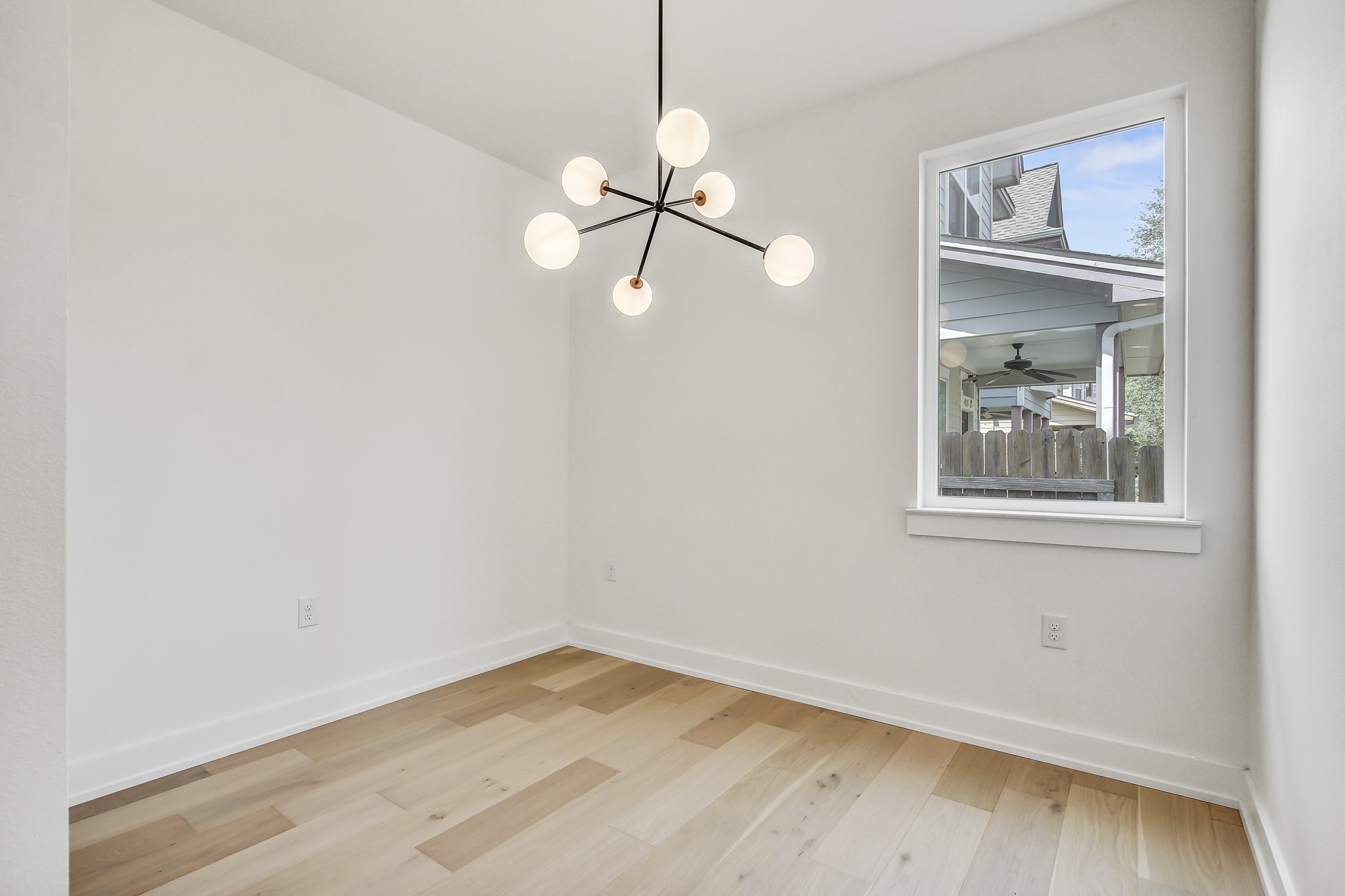 4127 East 12th Street, Unit 3 Austin, TX 78721 - Photo 13 of 29 Unfurnished room with baseboards, wood finished floors, and a chandelier