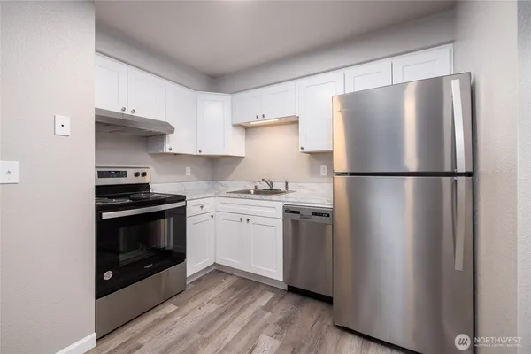 a kitchen with a refrigerator and a stove top oven