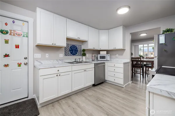 a kitchen with granite countertop cabinets a sink and white appliances