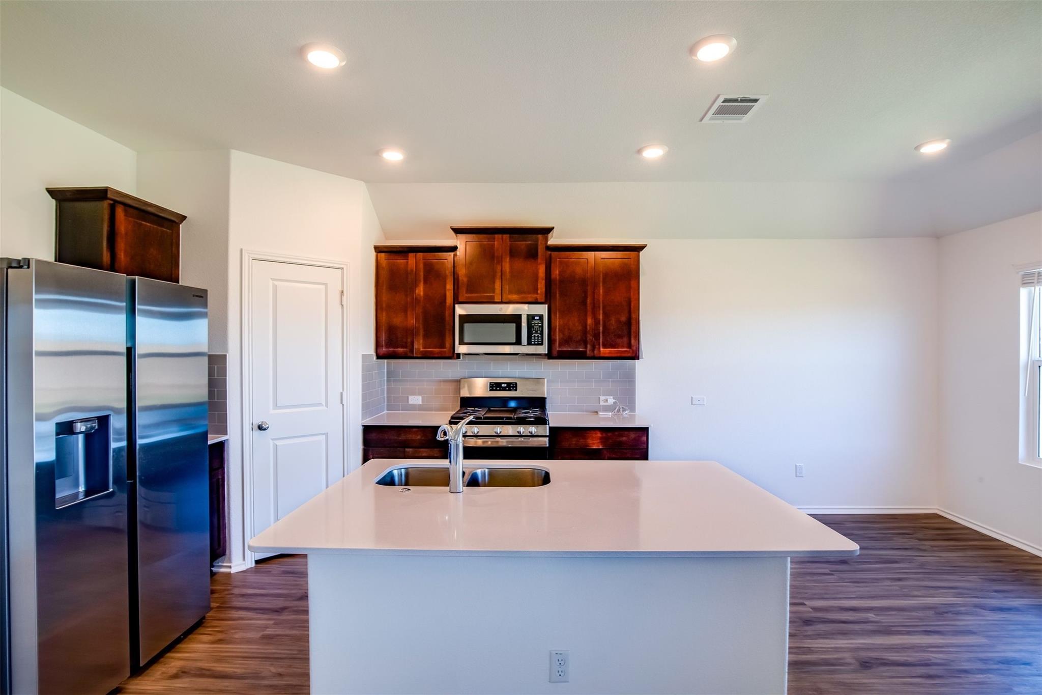 614 Milliner Loop Hutto, TX 78634 - Photo 21 of 25 A well-appointed kitchen showcasing a central island and modern stainless steel appliances.