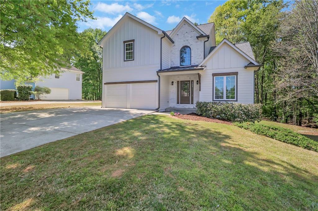 6259 Spring Lake Drive Flowery Branch, GA 30542 - Photo 2 of 35 a front view of a house with a yard and garage