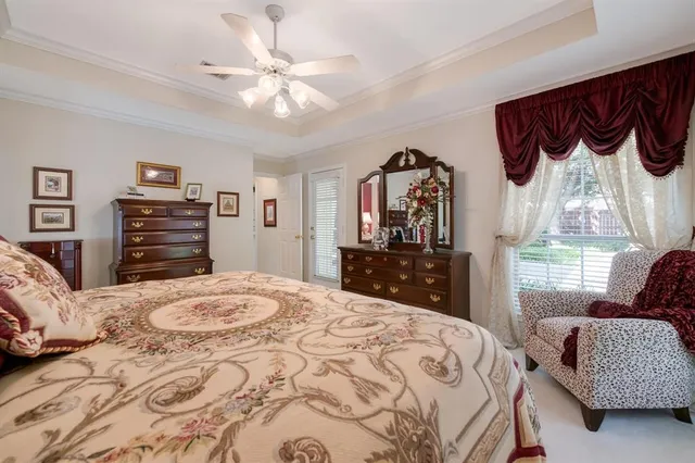 a bedroom with a bed a dresser and a chandelier