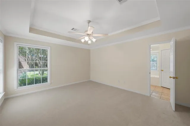 an empty room with windows and fan