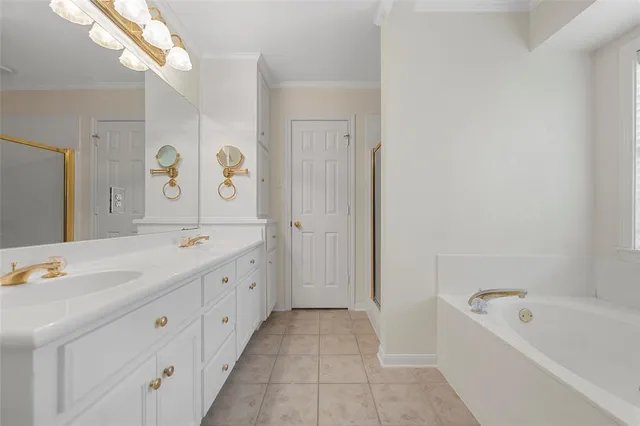 a spacious bathroom with a double vanity sink a mirror and a bathtub