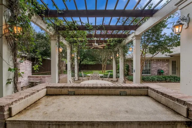 a view of house with a large windows and plants