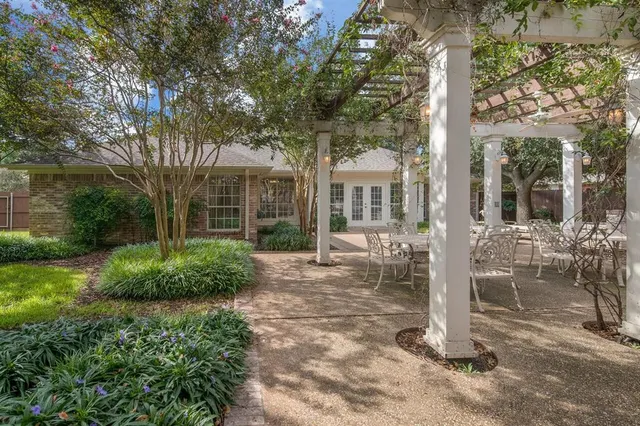 a view of a house with backyard garden and tree