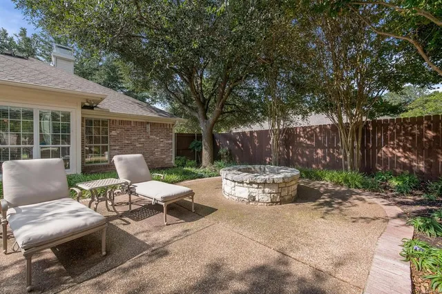 a view of a patio with table and chairs and wooden fence