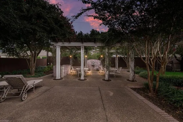 a view of a patio with table and chairs and a large tree