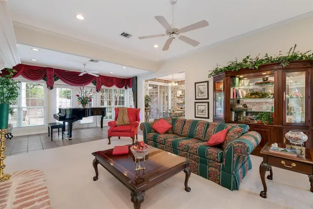 a living room with furniture a floor to ceiling window and a flat screen tv