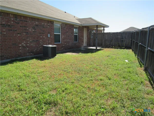 a view of house with backyard and a garden