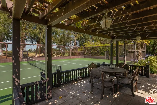 a patio with glass top table and chairs