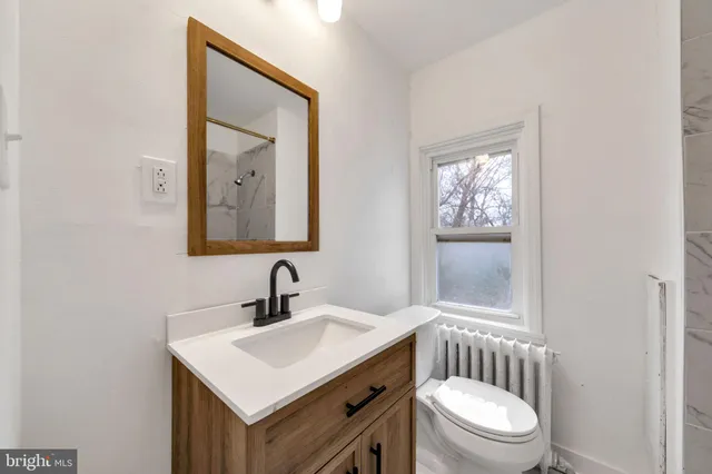 a bathroom with a toilet a sink and mirror