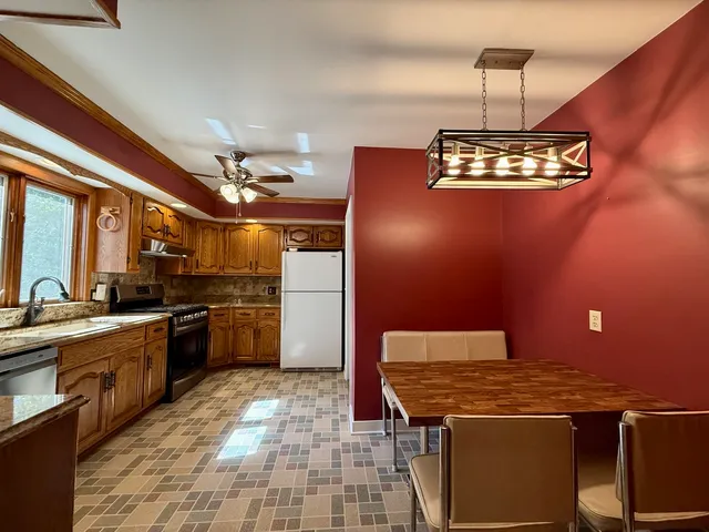 a kitchen with stainless steel appliances granite countertop a stove a sink dishwasher and a refrigerator