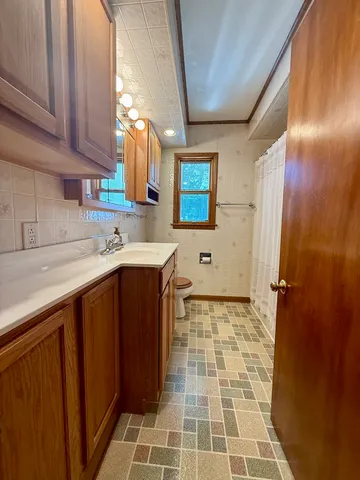 a bathroom with a sink a toilet and a mirror