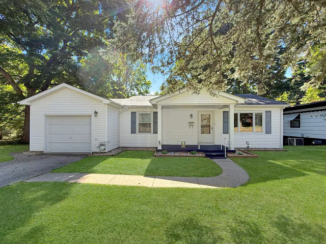 a front view of a house with a yard and trees