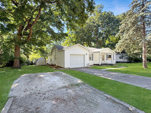a view of a yard in front of a house with large trees