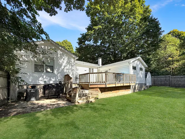 a view of a house with a yard and sitting area