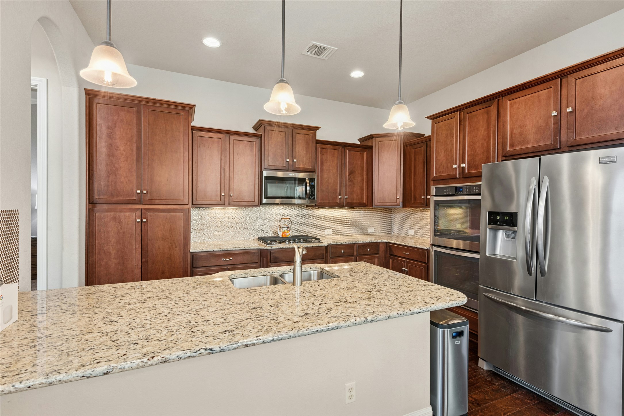 116 Evolutions Path Lakeway, TX 78738 - Photo 11 of 34 Kitchen featuring stainless steel appliances, decorative backsplash, light stone countertops, and pendant lighting