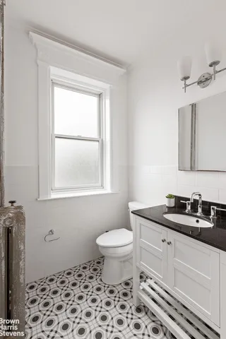 a bathroom with a granite countertop sink a toilet and a mirror