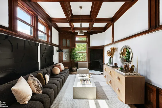 a living room with furniture fireplace and a large window