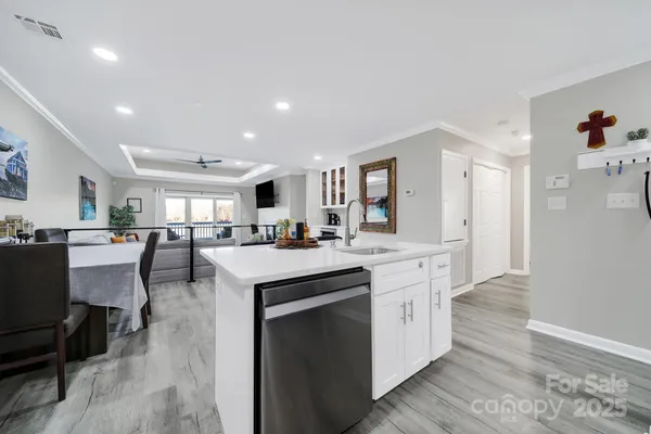 a kitchen with white cabinets and sink