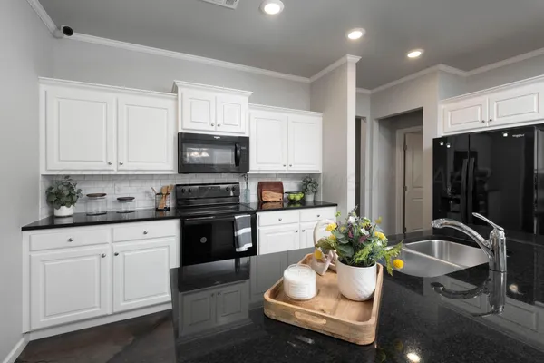 a kitchen with a sink stove and white cabinets