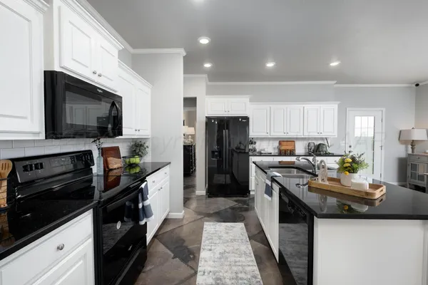a kitchen with stainless steel appliances kitchen island granite countertop a stove sink and refrigerator