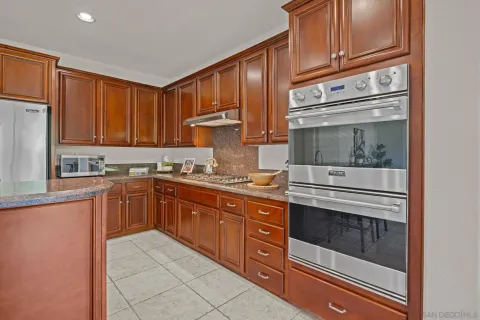 a kitchen with stainless steel appliances granite countertop a stove and cabinets