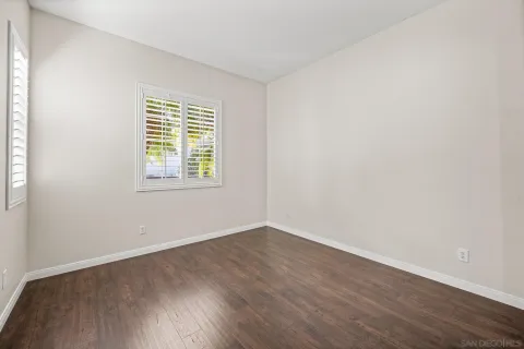 an empty room with wooden floor and a window