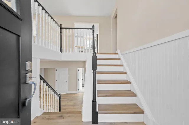 a view of staircase with railing and white walls