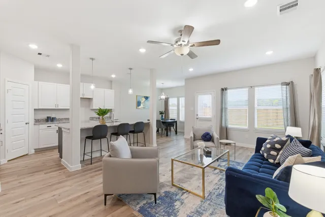 a living room with furniture kitchen and a chandelier