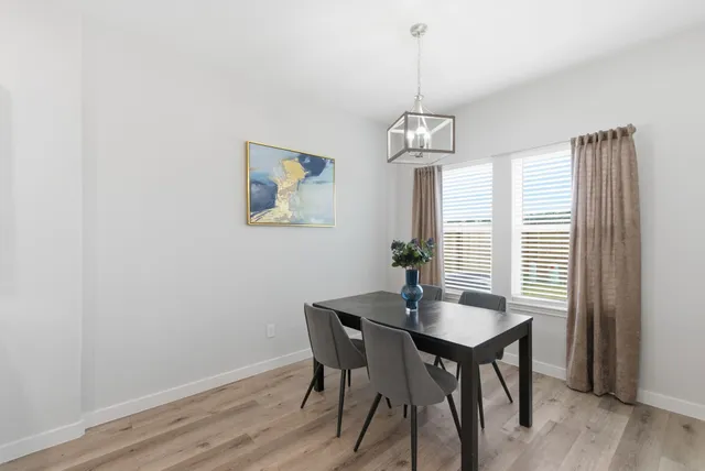 a dining room with wooden floor and a chandelier