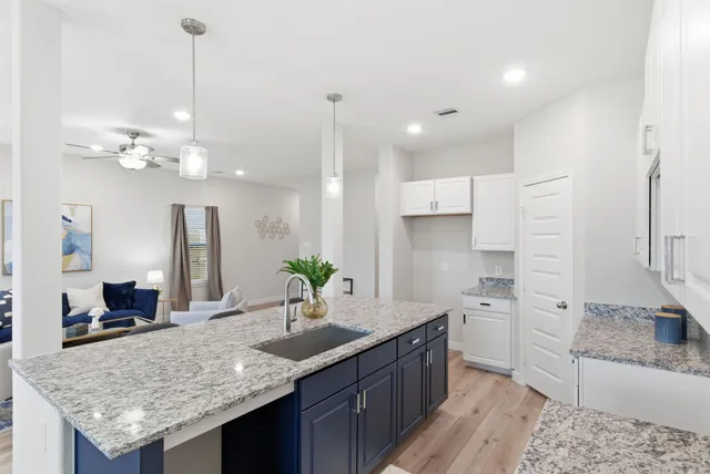 a kitchen with granite countertop a sink a center island and stainless steel appliances