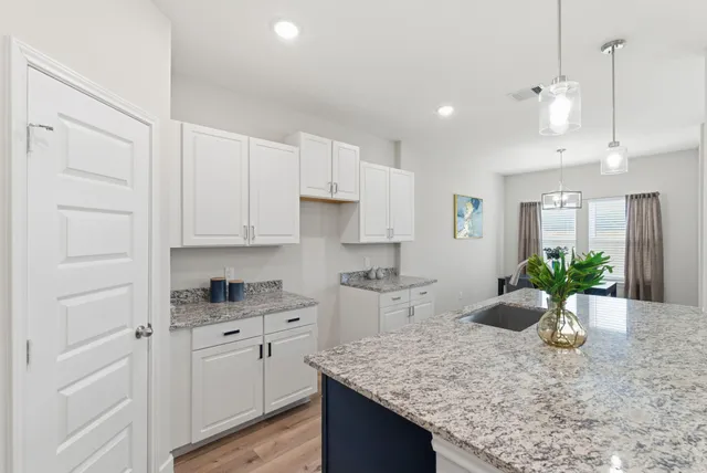 a kitchen with a white center island and cabinets