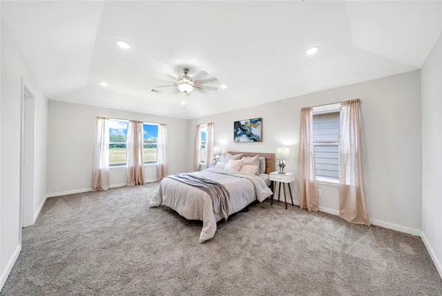a spacious bedroom with a bed and a chandelier