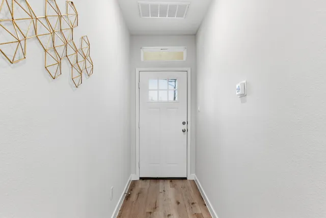 a view of a hallway with wooden floor and closet